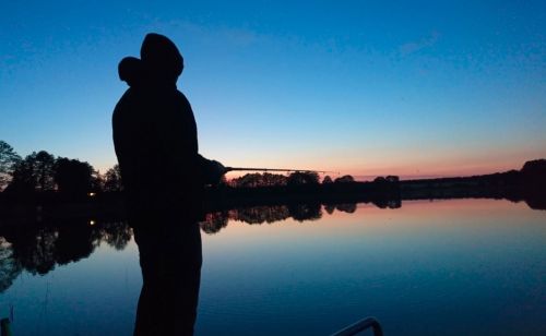 Angler am See bei Sonnenuntergang
